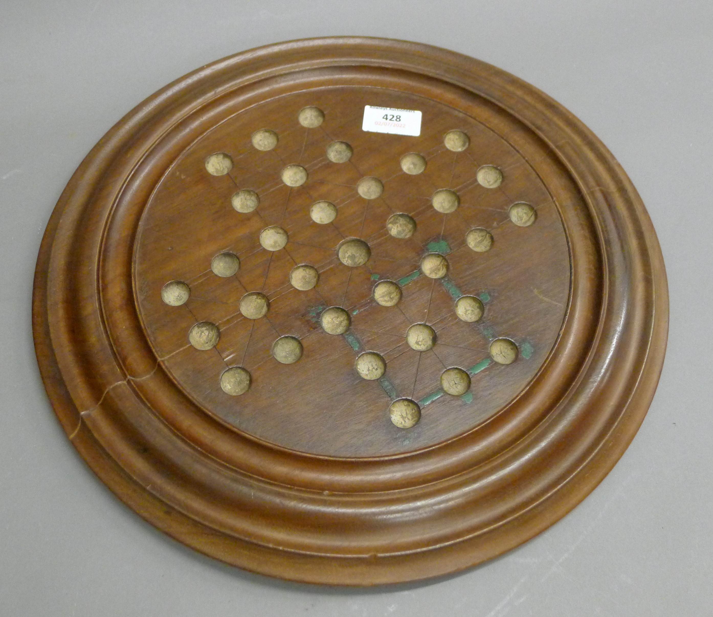 A Victorian mahogany solitaire board. 40 cm diameter.