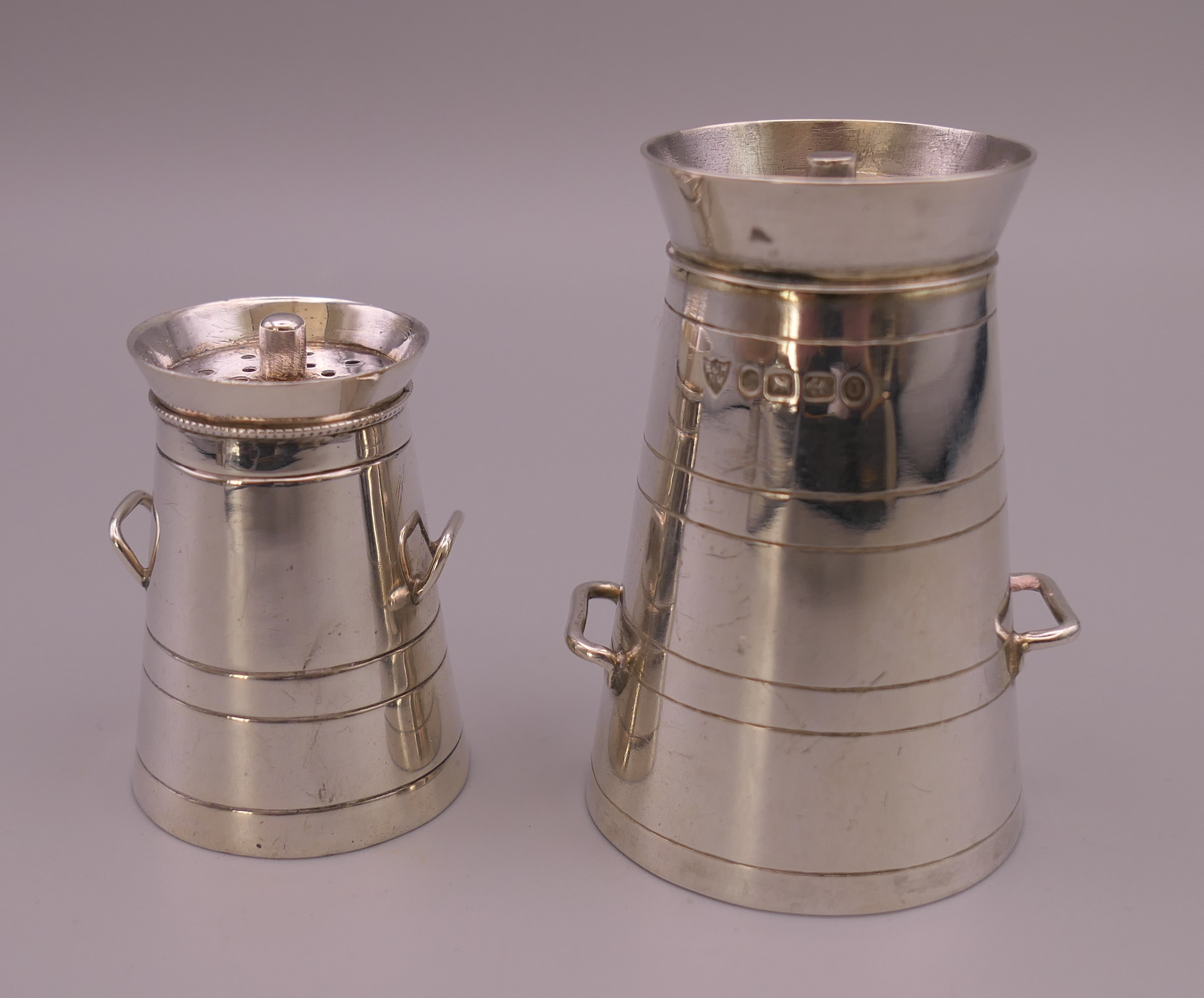 Two silver peppers formed as milk churns. 6 cm high and 4 cm high. 62.8 grammes.