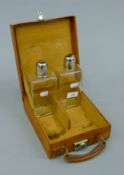 A small leather travelling case containing two bottles. Case 20 cm wide, 6.5 cm deep.