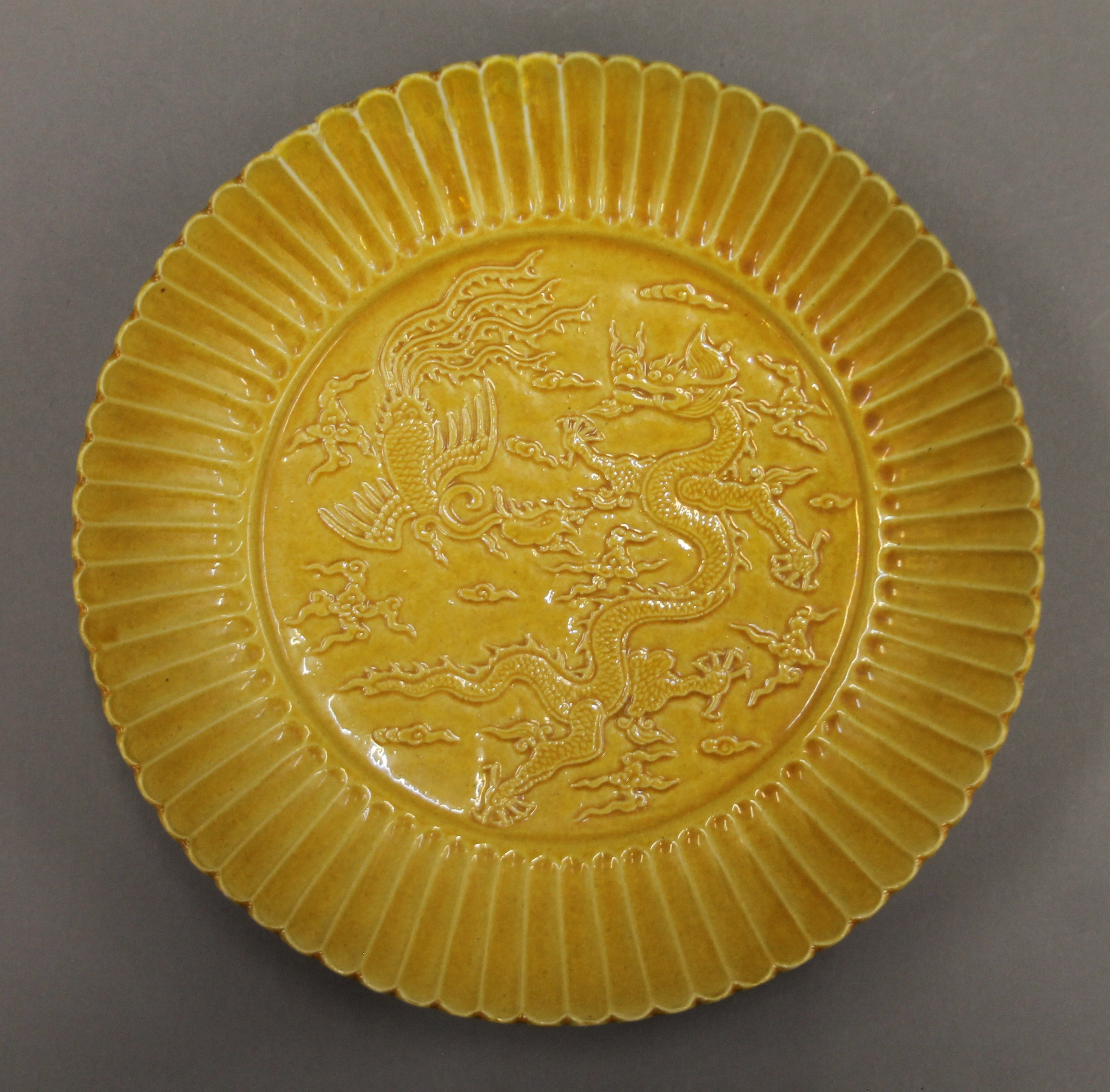 A Chinese yellow porcelain dish decorated with a dragon and a phoenix. 22.5 cm diameter. - Image 2 of 4