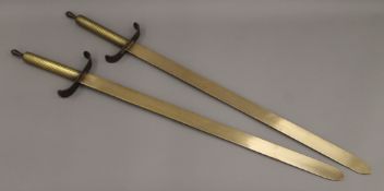 A pair of brass swords. 80 cm long.