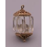 A 9 ct gold mounted crystal lantern charm. 2.6 cm high. 8.3 grammes total weight.