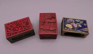 Two cinnabar match holders and a cloisonne match holder. The largest 6 cm high.