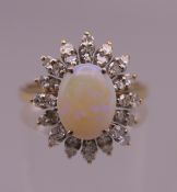 An 18 ct gold opal and diamond cluster ring. Ring size O. 4.9 grammes total weight.