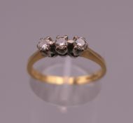 An 18 ct gold diamond trilogy ring. Ring size O. 2.6 grammes total weight.