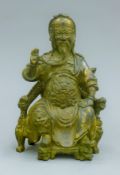 A gilt bronze model of a seated deity. 20.5 cm high.