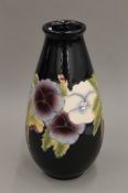 A florally decorated porcelain vase, signed W Moorcroft. 31 cm high.