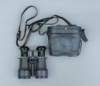 A pair of French field glasses with inset compass, cased. 13.5 cm wide overall.