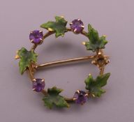 A small Continental 14 ct gold amethyst and enamel leaf wreath brooch. 2 cm diameter.