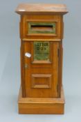 A wooden post box. 50 cm high.