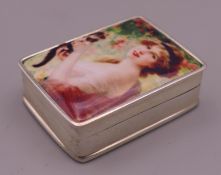 A silver pill box depicting a girl and her cat. 3 cm high.