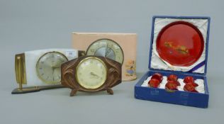 Three clocks and a Saki set. The largest clock 28 cm wide.