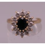 A 9 ct gold sapphire and clear stone ring. Ring size P. 2.5 grammes total weight.