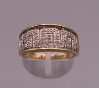 A 9 ct gold diamond Greek key design ring. Ring size Q. 3.3 grammes total weight.