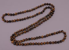 A string of tigers eye beads. 120 cm long.