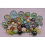 Four antique glass marbles (three approximately 1 inch diameter and the other 15/16th of an inch