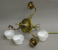 A three-branch brass chandelier with two tone glass shades.