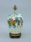 A Chinese table lamp, hand painted with boys in a garden. 42 cm high overall.