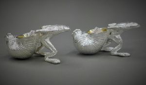 A pair of silver plated frog form salts. 10 cm long.