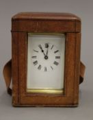 A brass carriage clock, housed in a leather travelling case. 13.5 cm high overall.