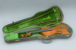 A cased violin. 59 cm long.