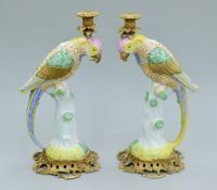 A pair of bronze and porcelain parrot formed candlesticks. 41 cm high.