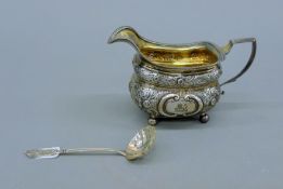 A silver milk jug and a sifter spoon. The former 10 cm high. 220.4 grammes.