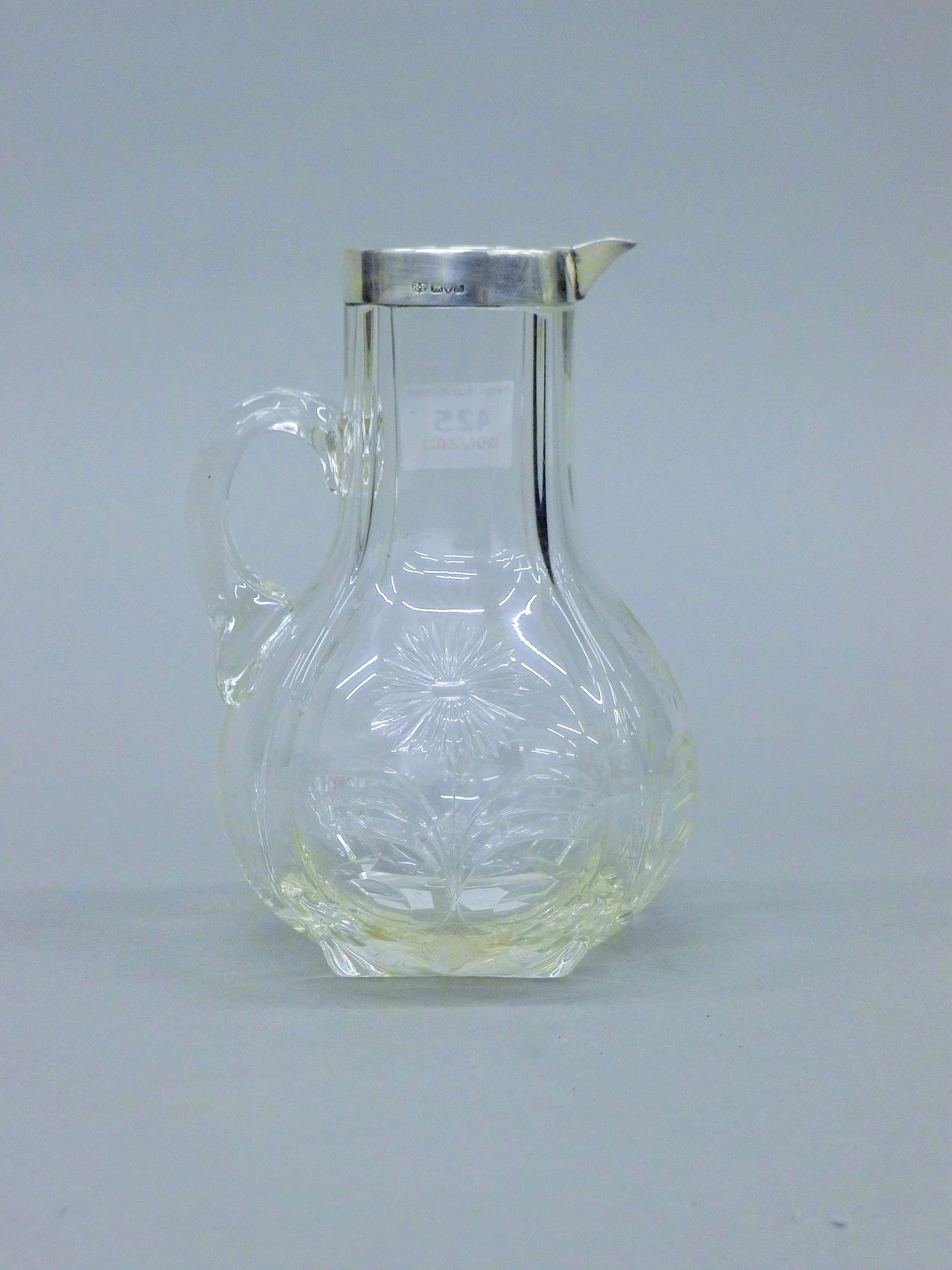 A silver rimmed and glass claret jug, hallmarked for Chester 1901 by Robert Pringle and Son.
