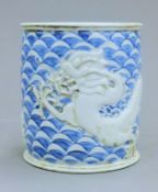 A Chinese porcelain blue and white brush pot decorated with fish. 11.5 cm high.