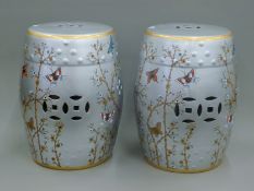 A pair of silver ground barrel seats decorated with butterflies. 46 cm high.