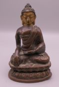 A bronze gold faced model of Buddha. 9.5 cm high.