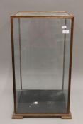 A glass display case. 39 cm wide x 39 cm deep x 72 cm high.