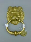 A brass lion mask door knocker. 19 cm high.