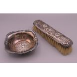 An 800 silver dish and a silver backed brush. Dish 10.5 cm wide, brush 17 cm long. The former 41.