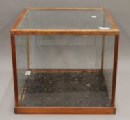 A glass display case. 46.5 cm wide x 46.5 cm deep x 40.5 cm high.