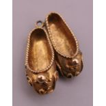 A 9 ct gold charm formed as a pair of slippers. 2.5 cm long. 4.5 grammes.