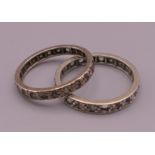 Two unmarked white metal clear stone eternity rings. Ring size N and P. 3.9 grammes total weight.