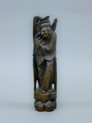 A Chinese hardwood figure of an immortal, with silver inlay decoration. 29 cm high.