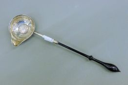 A Georgian coin set unmarked silver toddy ladle. 28 cm long.