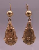 A pair of 9 ct gold pendant earrings, with relief embossed decoration with lock fittings. 5 cm high.
