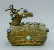 A Chinese white metal box formed as a deer decorated with various semi-precious stones. 16 cm long.