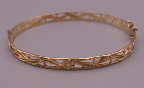 A 9 ct gold pierced bangle form bracelet. 6 cm wide. 7.6 grammes.