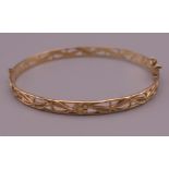 A 9 ct gold pierced bangle form bracelet. 6 cm wide. 7.6 grammes.