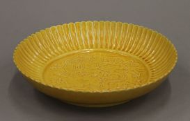A Chinese yellow porcelain dish decorated with a dragon and a phoenix. 22.5 cm diameter.