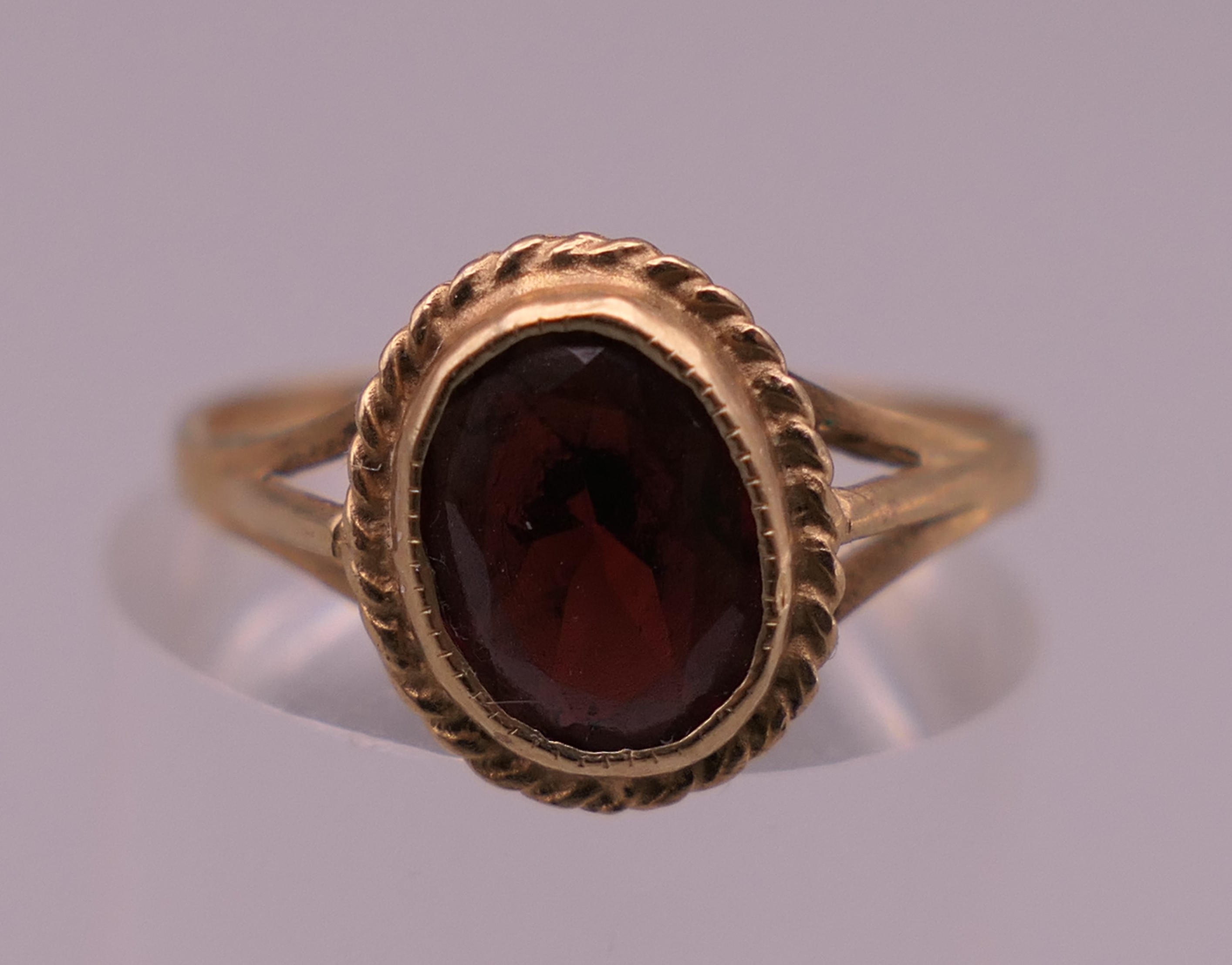 A 9 ct gold garnet ring. Ring size L/M. 1.5 grammes total weight.