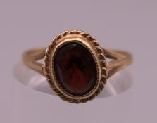 A 9 ct gold garnet ring. Ring size L/M. 1.5 grammes total weight.