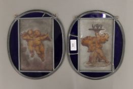 A pair of leaded glass panels, one decorated with cherubs and the other with putto. Each 24.