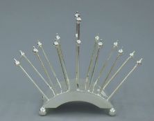 A Christopher Dresser style silver plated toast rack. 21.5 cm long.