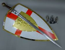 A replica sword, shield and three model knights. The sword 103 cm high.