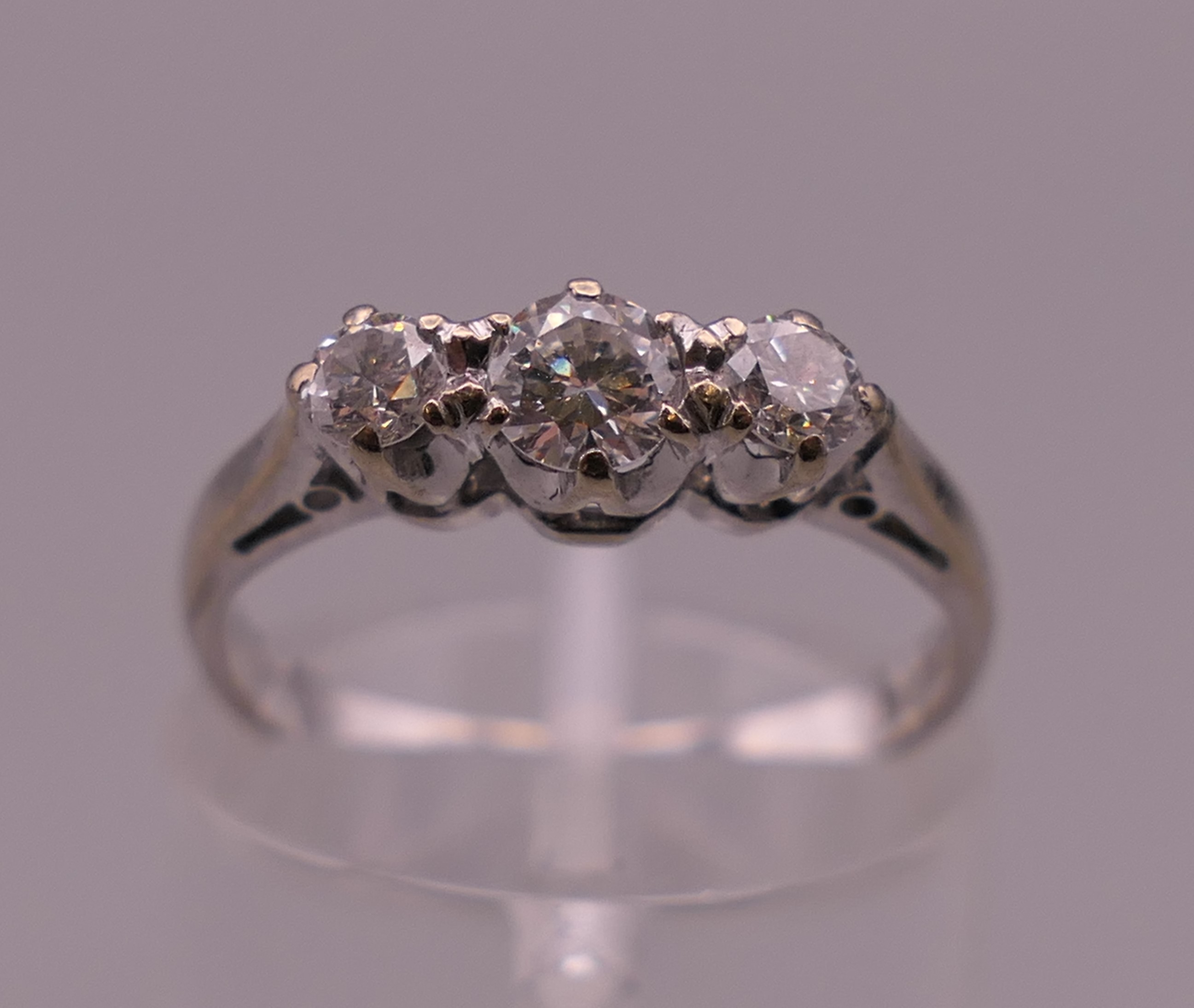 An 18 ct white gold three stone diamond ring. Ring size K/L. 2.5 grammes total weight.